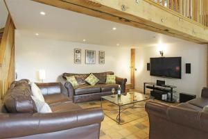 a living room with leather furniture and a flat screen tv at 5 Bed in Beccles oc-ksf in Wangford