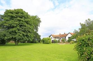 a large yard with a house and a tree at 5 Bed in Beccles oc-ksf in Wangford