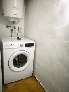 a white washing machine in a corner of a room at Can Pep Frit in Ibiza Town