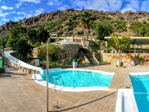 a swimming pool with a mountain in the background at Monseñor in Playa del Cura