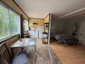 a room with a kitchen and a bed and a table at Lush's Cottages in Cormack
