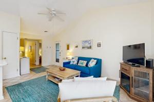 a living room with a blue couch and a tv at Sea Colony - 7903 Timberlake in Bethany Beach