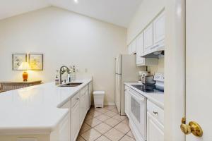 a kitchen with white cabinets and a white refrigerator at Sea Colony - 7903 Timberlake in Bethany Beach +8 photos