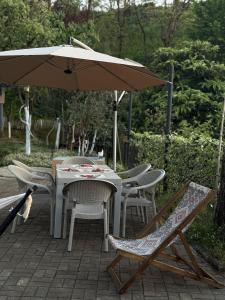 ein Tisch und Stühle unter einem Sonnenschirm auf einer Terrasse in der Unterkunft Sameba House in Khuts'ubani + 10 Fotos