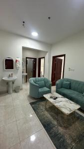 a living room with two blue couches and a table at شقق ابو طلال المفروشة in Sakakah