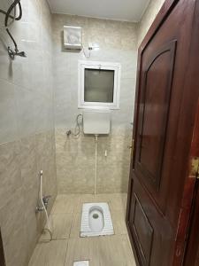 a bathroom with a toilet with a tv on the wall at شقق ابو طلال المفروشة in Sakakah