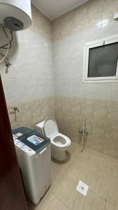 a bathroom with a toilet and a trash can at شقق ابو طلال المفروشة in Sakakah