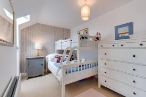 a childs bedroom with a white bunk bed and a dresser at Moo House in Beadnell