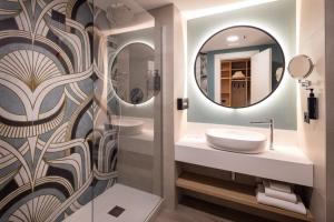 a bathroom with two sinks and a mirror at Holiday Inn Naples by IHG in Naples