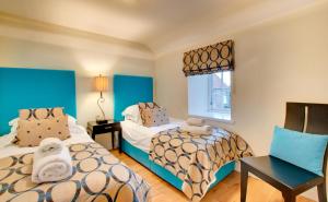 a room with two beds and a table and a window at 2 Bed in Belford oc-gd1023 in Warenford