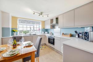 a kitchen with a table and a dining room at Angorfa Aberaeron Apartment in Aberaeron