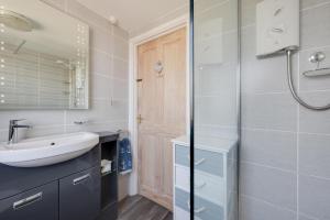 a bathroom with a sink and a mirror at Angorfa Aberaeron Apartment in Aberaeron +24 photos