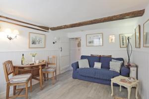 a living room with a blue couch and a table at 1 Bed in Southwold oc-aapebb in Southwold