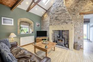 a living room with a large stone fireplace at Boca Chica Cottage in Cambois
