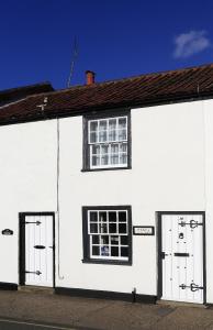 a white building with two windows and two doors at 1 Bed in Southwold oc-aapebb in Southwold +1 photo