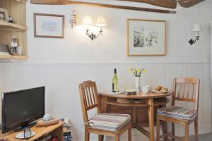 a dining room with a table and a television at 1 Bed in Southwold oc-aapebb in Southwold