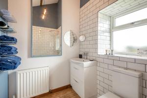 a white bathroom with a sink and a mirror at Boca Chica Cottage in Cambois +61 photos