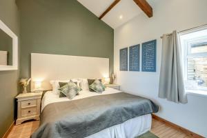 a bedroom with a bed with two pillows and a window at Boca Chica Cottage in Cambois