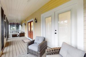 a porch with two chairs and a door on a house at The Peninsula --- 33129 Serenity Circle #87 in Millsboro