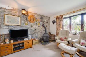 a living room with a tv and a stone wall at 3 Bed in Llanidloes oc-waa246 in Llangurig