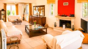 a living room with red walls and a fireplace at Villa Rodothea in Khelmáta