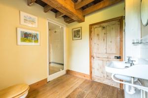 a bathroom with a sink and a wooden door at 4 Bed in Reepham oc-497 in Reepham +30 photos