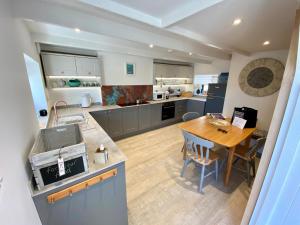 a large kitchen with a wooden table and a dining room at Red Herring in Craster
