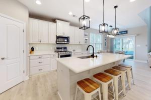 a kitchen with white cabinets and a kitchen island with bar stools at Bishops Landing --- 38480 Carroll Dr in Millville +34 photos