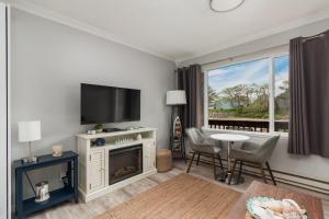a living room with a fireplace and a flat screen tv at Beach Captain - Meredith Lodging in Neskowin