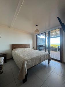 a bedroom with a bed and a large window at Almar House in Guaquen