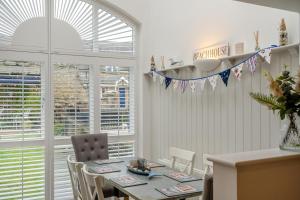 a dining room with a table and chairs and a window at Smugglers Hide in Beadnell