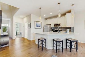 a kitchen with a counter and some stools in it at Bear Trap Dunes -- 13 Village Green in Ocean View +43 photos