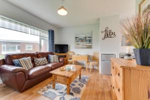 a living room with a brown leather couch and a table at 2 Bed in Walcott oc-2282 in Walcott
