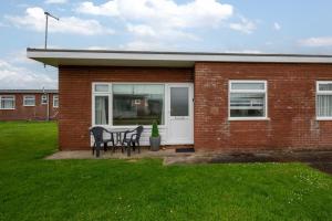 a brick house with a table and chairs in a yard at 2 Bed in Walcott oc-2282 in Walcott