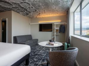 a room with a bed and a table and a couch at ibis Clermont Ferrand Montferrand in Clermont-Ferrand