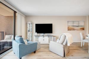 a living room with two chairs and a flat screen tv at Sea Colony --- 208 Brandywine House in Bethany Beach