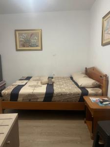 a bedroom with two beds and a table and a picture at Private Rooms with a Beautiful Veranda in Heraklio