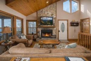 a living room with a fireplace and a stone wall at Serenity in Blowing Rock