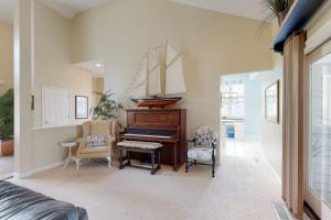 a living room with a piano and two chairs at Salt Pond --- 314 Walkabout Rd in Bethany Beach