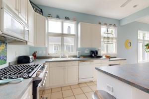 a kitchen with white cabinets and a stove top oven at Salt Pond --- 314 Walkabout Rd in Bethany Beach +29 photos