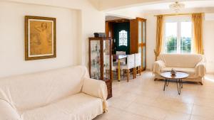 a living room with a couch and chairs and a table at Villa Rodothea in Khelmáta