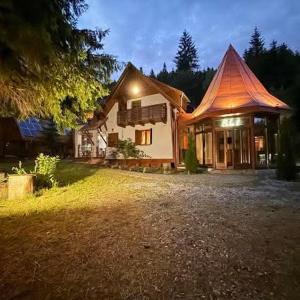 a house with a lit up roof on a yard at Red Lake Inn in Gheorgheni