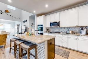 a kitchen with white cabinets and a large island with bar stools at Bayside Resort - 28031 Sea Dock in Selbyville
