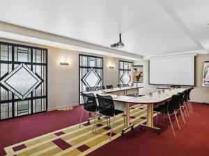a conference room with a long table and chairs and a whiteboard at Mercure Paris Opéra Faubourg Montmartre in Paris