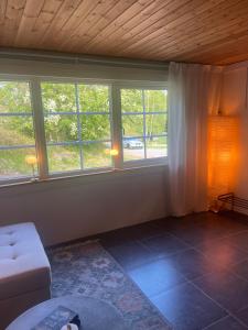 a living room with windows and a white couch at Gästhus med båtplats in Kvicksund