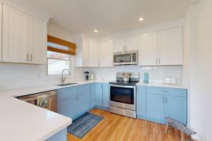 a blue kitchen with white cabinets and a wooden floor at South Bethany --- 106 Brandywine Drive in Bethany Beach +20 photos