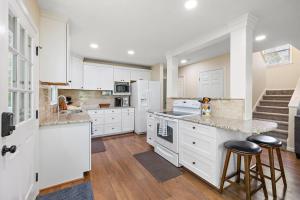 a kitchen with white cabinets and a counter with stools at Heron Hideaway in Wilkesboro