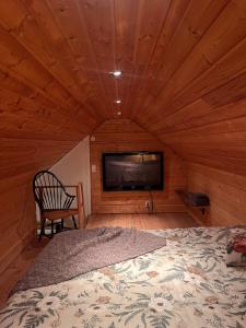a room with a bed and a television in a cabin at Gästhus med båtplats in Kvicksund