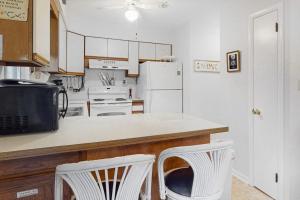 a kitchen with white appliances and two white chairs at Bethany Pines -- 412 Bethany Drive in Bethany Beach +19 photos