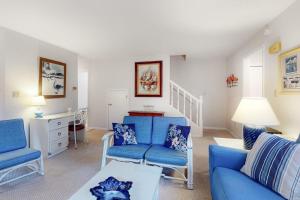 a living room with two blue chairs and a table at Bethany Pines -- 412 Bethany Drive in Bethany Beach